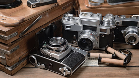 Vintage camera and travel suitcase on wooden table. Travel concept.の写真素材