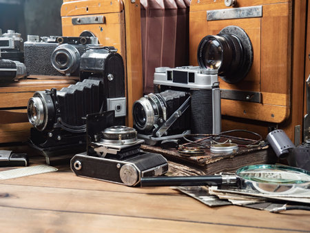Vintage camera and old photos on a wooden table in the room