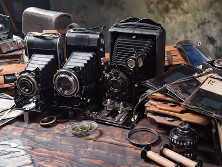 Old camera and old photos on a wooden table in a photo studioの写真素材