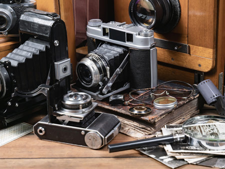 Old camera, lens and other objects on a wooden table in a photo studio