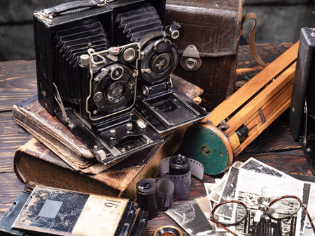 Vintage camera and old photos on a wooden table. Retro style.