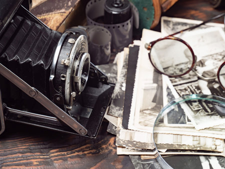 Vintage camera and old photos on a wooden table. Retro styleの写真素材