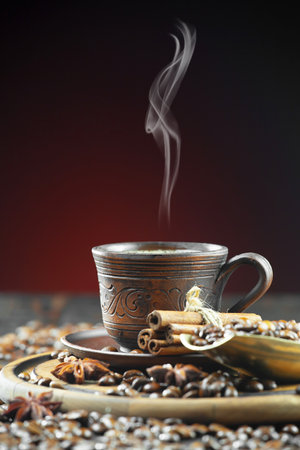 Coffee cup with coffee beans and cinnamon on a black backgroundの写真素材