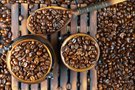 Coffee beans in a cup on a wooden background, top viewの写真素材