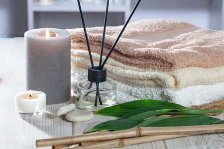 Spa and aromatherapy setting with towels, candles and bamboo sticksの写真素材