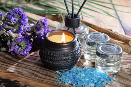 Spa still life with aromatic candles and lavender on wooden background
