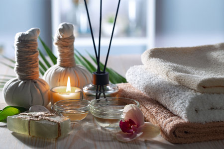 Spa composition with candles, towels and orchid on wooden tableの写真素材