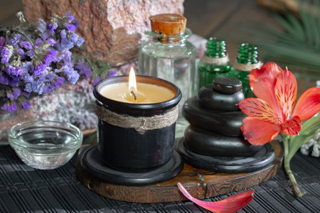 Spa still life with candles, stones and flowers on wooden background