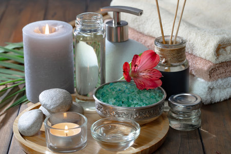 Spa treatment with sea salt, candles and towels on wooden tableの写真素材