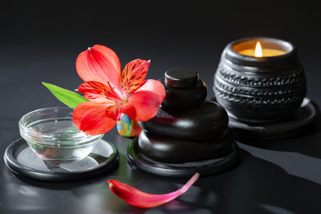Spa still life with red flowers, candles and zen stones