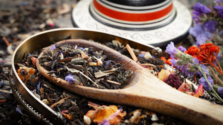 Black tea with lavender and rose petals in a wooden spoonの写真素材