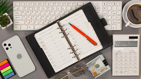 Office desk table with notepad, computer keyboard, coffee cup and calculator