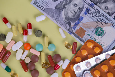 Pills and capsules on a green background. Top view