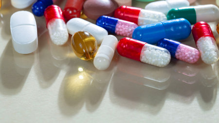Close up of colorful pills and capsules on white background with copy space