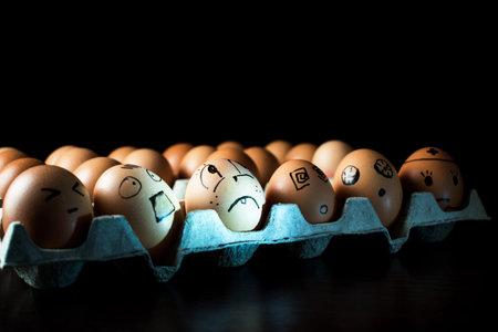 Emotional chicken eggs in a tray. Interesting grimaces drawn on chicken eggs.