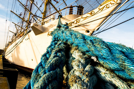 A large ship is moored with ropes.