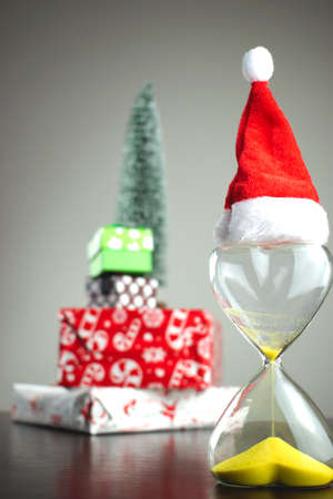 Hourglass on the background of Christmas gifts. Christmas is comingの写真素材