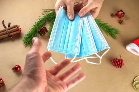 Antiviral masks as a Christmas gift. A guy gives a girl antiviral masks on Christmas night