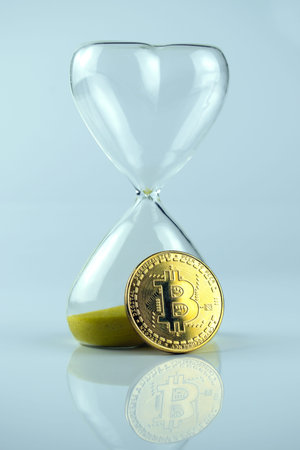 Bitcoin coin with an hourglass. The rapid growth of the cryptocurrencyの写真素材