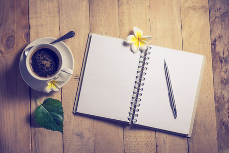 write a note to a notebook and a cup of coffeeの写真素材