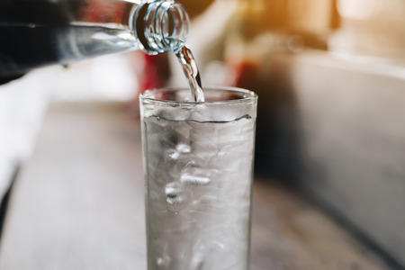 Pour drinking water into the glass. Pour cool drinking water. Ice in glass and drinking water. Clean drinking water.の写真素材