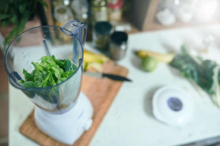 Green smoothie with blender in home kitchenの写真素材