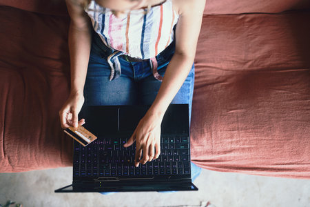 Cropped shot of a African woman doing online payment from aboveの写真素材