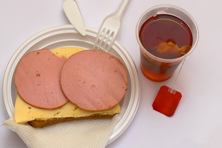 Rustic. A sandwich with sausage and cheese on a gray bread, Tea from a bag is welded in a single glassの写真素材