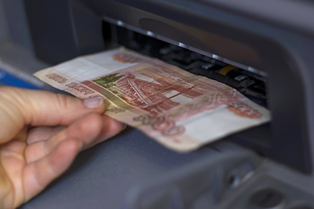 The hand gives bills from the ATMの写真素材