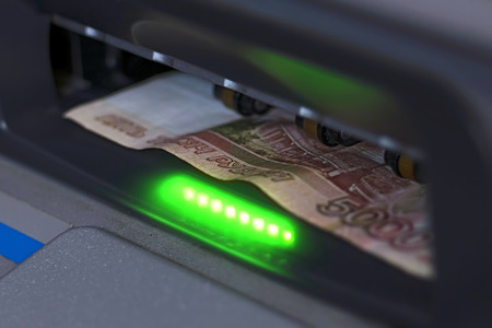 The note is inserted into the open ATM receiverの写真素材