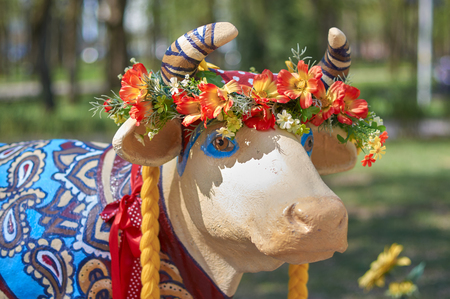 The head of a cow is decorated with a hat with beads and flowersの写真素材