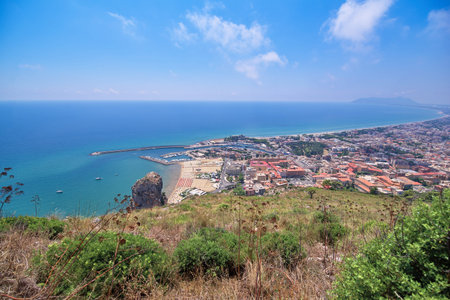 Sandy sea beach of the Italian coast, umbrellas and chaise lounges for tourists. The blue sky and the ocean waterの写真素材