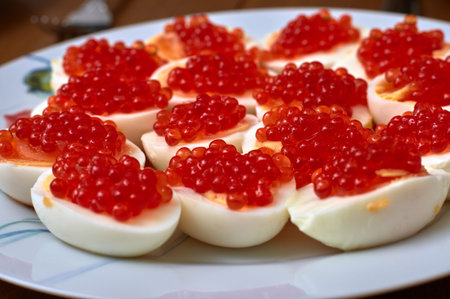 eggs with red caviar on a white plate, close-up