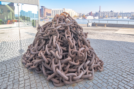 Rusty anchor chain piled up on the pier, close-upの写真素材