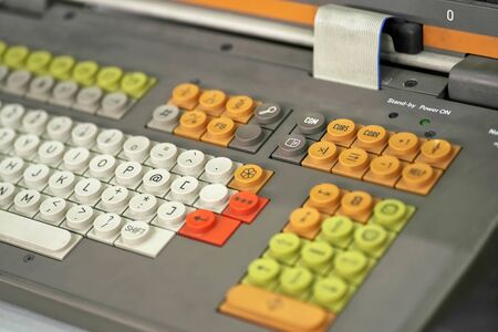 Old dirty keyboard from a computer from the last century, multi-colored buttons and cable loop close-upの写真素材