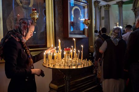 ST. PETERSBURG, RUSSIA - September 12, 2019: Preparing for a religious procession, an unknown believer lights an icon in the Kazan Cathedral in St. Petersburgのeditorial素材