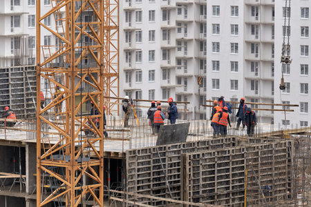Builders work at top floor of building a house. Armature and concrete plates