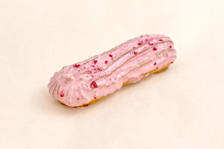Raspberry Eclair cake with pink cream, sprinkled with small pieces of raspberry. Delicious pastries...