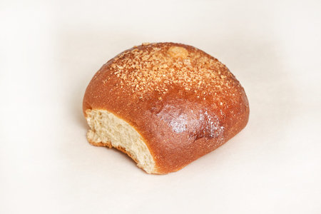 Fresh bread loaf sprinkled with grated walnut. Closeup on a light background. Delicious and healthy...