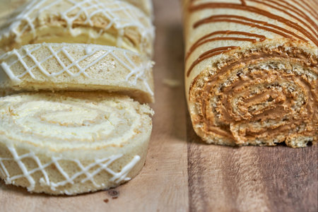 Two biscuit roll with dark and light stuffing on the background boards. Lemon loaf and condensed milk, close-upの写真素材