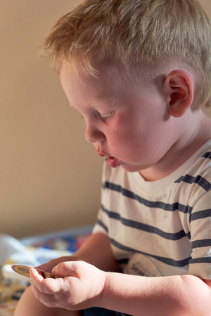 Portrait of a little boy with red hair in profile. Close-up, vertical shot