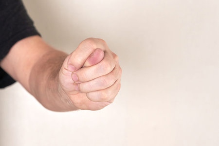 Fingers folded in a fig outstretched towards the camera