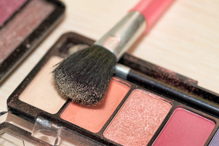 Open Box of Multicolored Eyeshadow with Makeup Brush