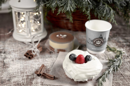 A cake decorated with blackberries and raspberries on a New Year table with a flashlight and a...
