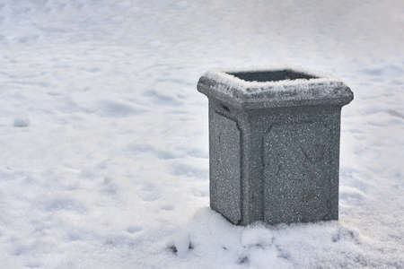 Stone urn for debris against the background of white snowの写真素材