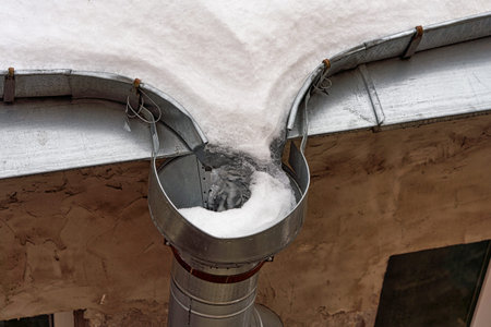Frozen roof gutter clogged with snow and ice