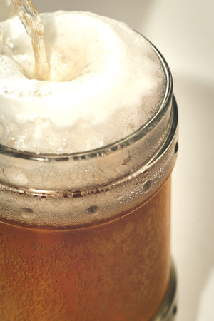 Clear glass with light beer and foam on top