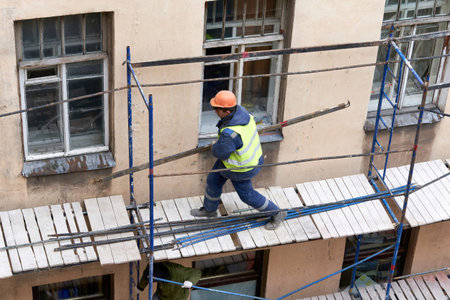 Saint Petersburg, Russia - April 24, 2021: Workers erect scaffolding to repair the facade of a...