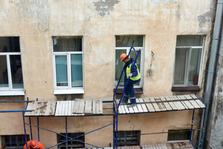 Saint Petersburg, Russia - April 24, 2021: Workers erect scaffolding to repair the facade of a...