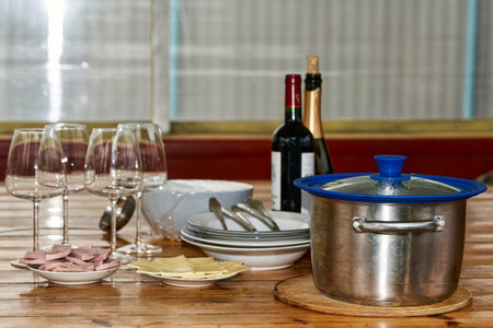 Bottles and glasses with dishes on a wooden table, preparing for dinner in the country